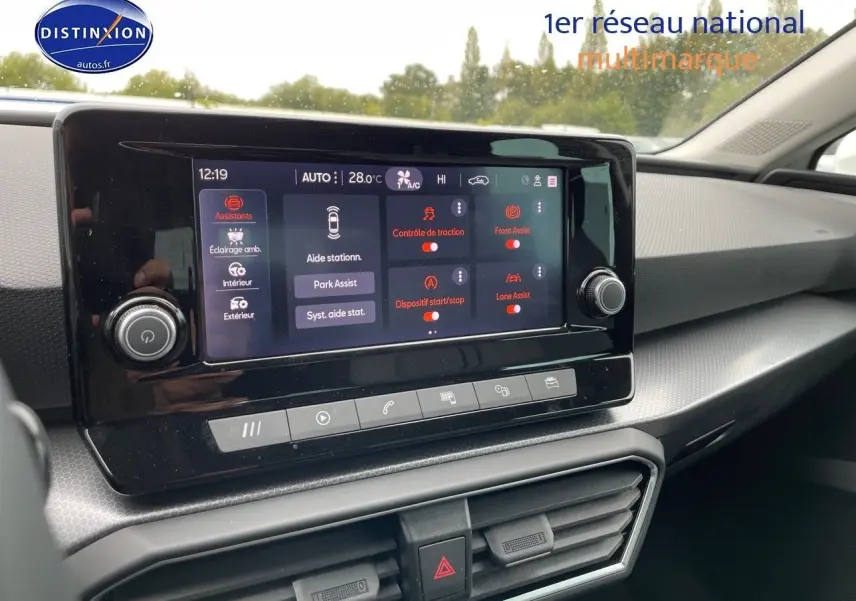 Écran tactile central du tableau de bord de la SEAT Leon IV blanche, affichant les assistances à la conduite.