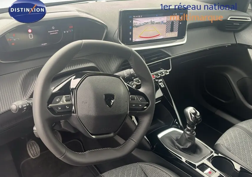 Intérieur du Peugeot 2008 2025 avec volant compact, tableau de bord numérique et levier de vitesse manuel visible côté conducteur.
