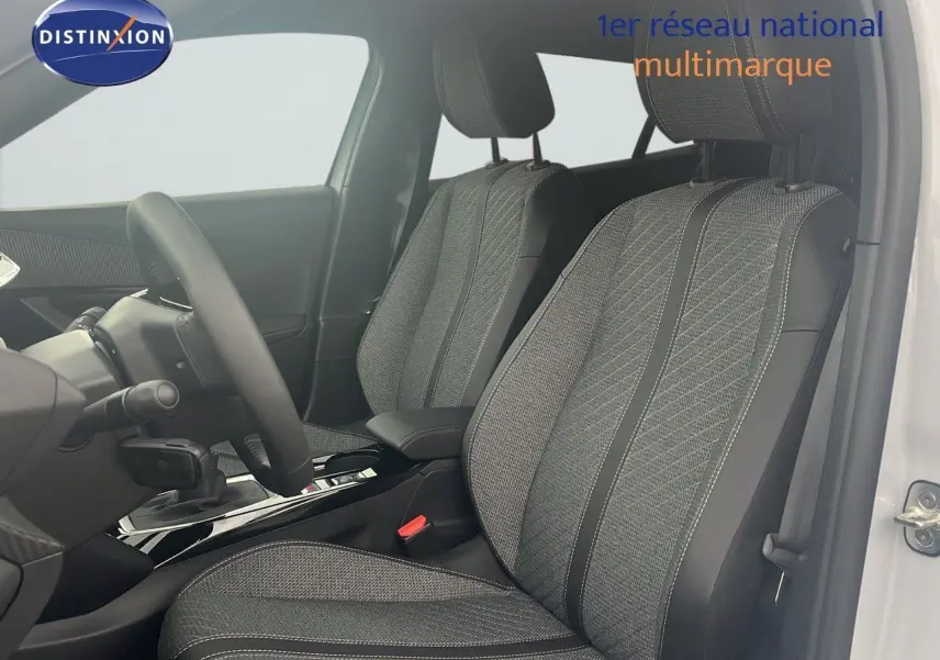 Intérieur de la Peugeot 2008 2025 en blanc, vue côté conducteur sur les sièges tissu noir et gris avec coutures contrastées.