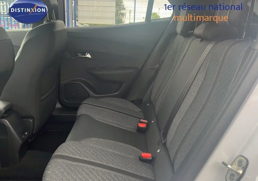 Vue latérale droite de l'intérieur arrière du Peugeot 2008 blanc Okenite, sièges tissu noir avec surpiqûres claires.
