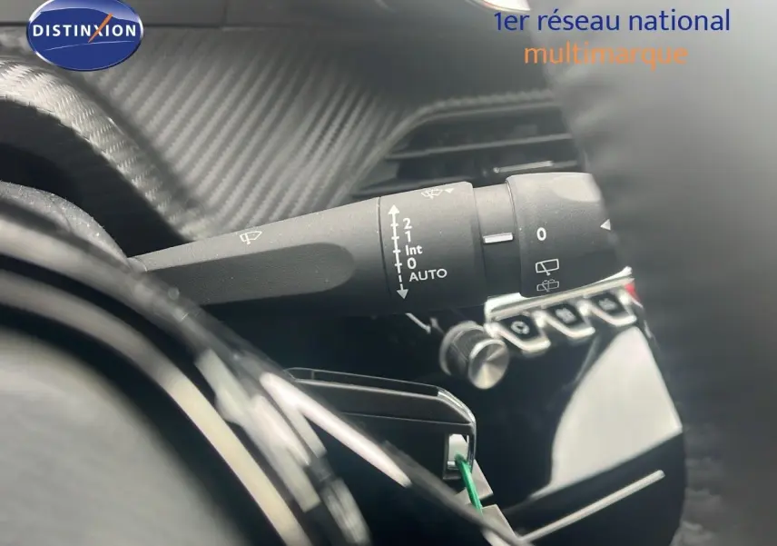 Gros plan sur la manette d'essuie-glace à gauche du volant dans l'habitacle du Peugeot 2008 blanc Okenite Metal.