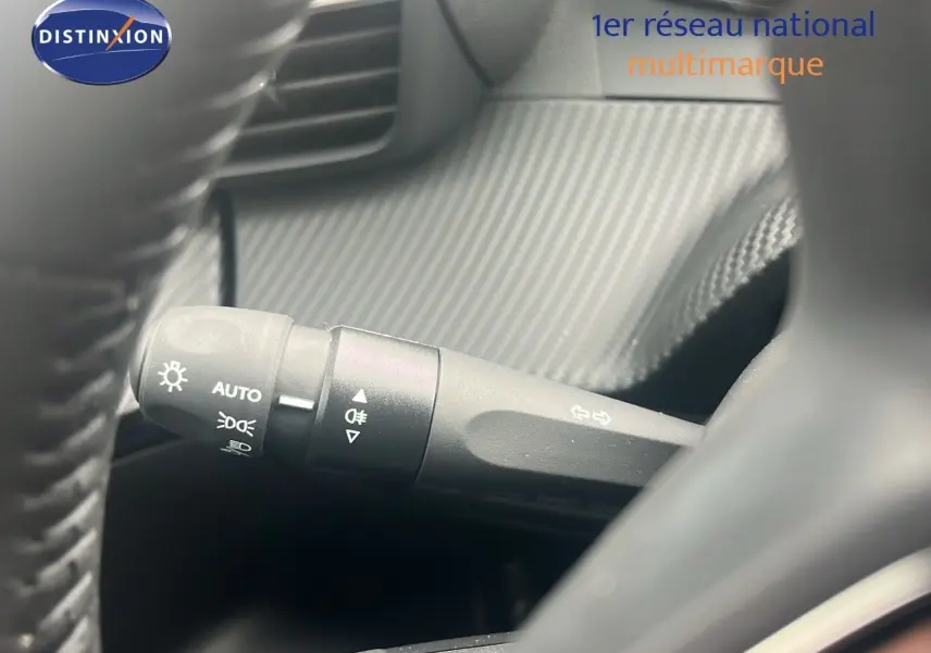 Gros plan sur la commande des feux du Peugeot 2008 blanc Okenite métal, côté gauche du volant.