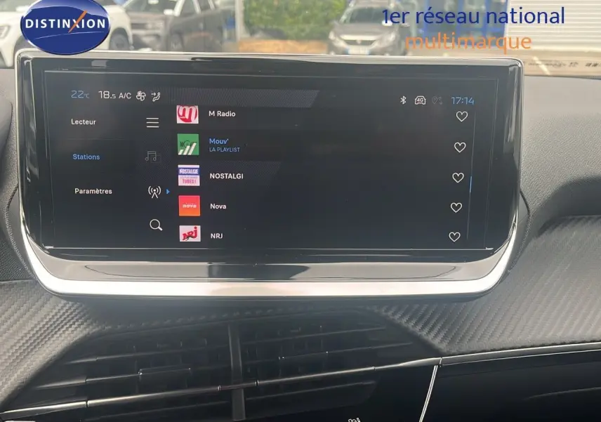 Écran tactile central affichant les stations radio dans l'habitacle du Peugeot 2008 blanc Okenite Metal.