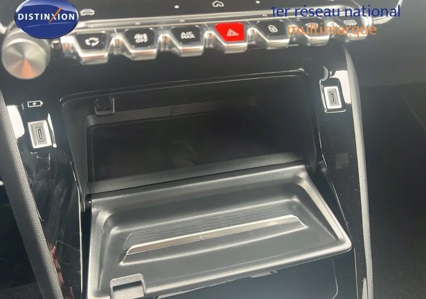 Gros plan sur la console centrale noire du Peugeot 2008 2025, avec rangements ouverts et commandes en chrome.