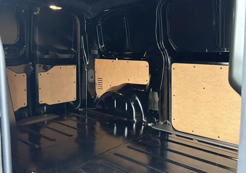 Intérieur de la zone de chargement du Citroën Jumpy noir Perla, vue latérale droite avec panneaux de protection bois.