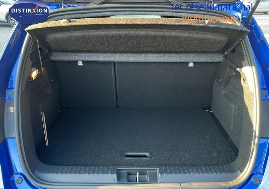 Coffre ouvert d'un Renault Captur E-Tech hybride 2025 bleu Iron Metal avec toit noir, vue arrière intérieure.