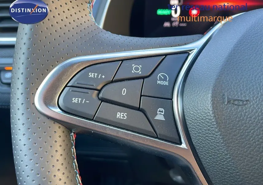 Gros plan sur les commandes du volant en cuir perforé du Renault Captur E-Tech hybride bleu iron metal avec toit noir.