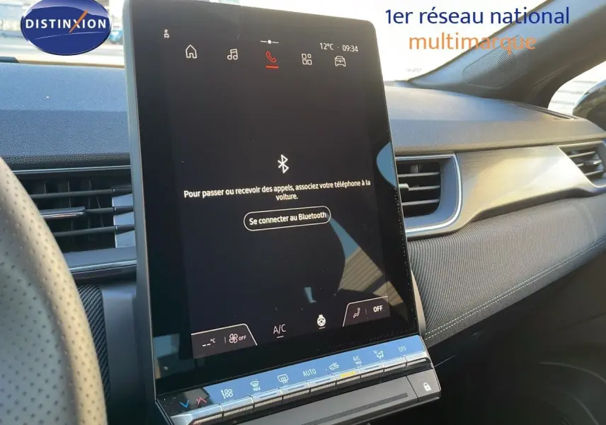 Vue intérieure du tableau de bord du Renault Captur E-Tech hybride 2025 avec écran tactile central vertical allumé.