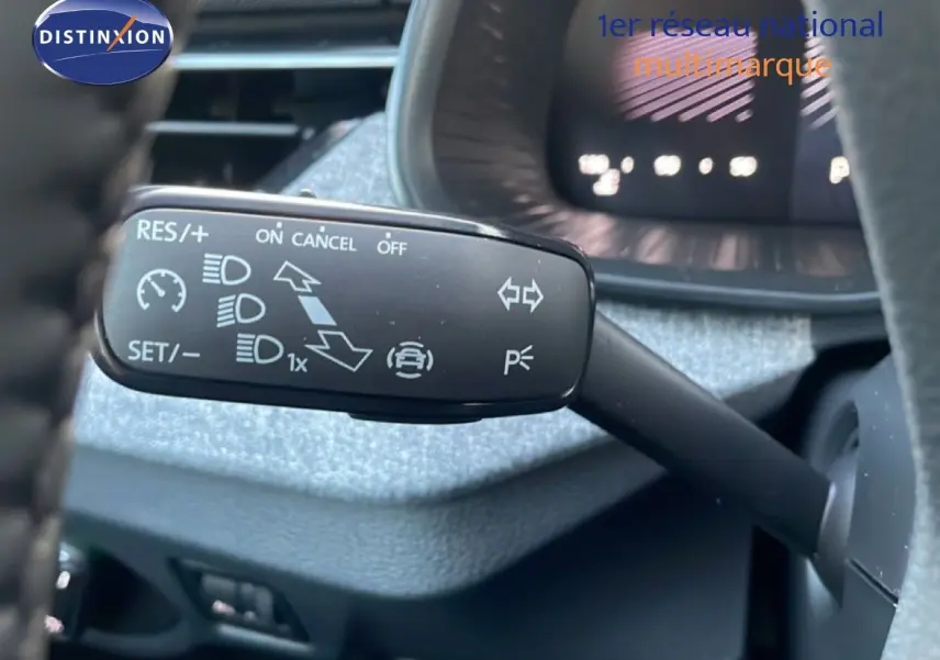 Gros plan sur la commande de régulateur de vitesse au volant du Skoda Kamiq gris argent 2025, intérieur gris-noir.