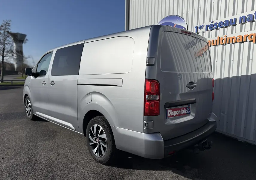 Vue 3/4 arrière droite d’un FIAT Scudo cabine approfondie gris 2022 avec jantes bi-ton et attelage visible.