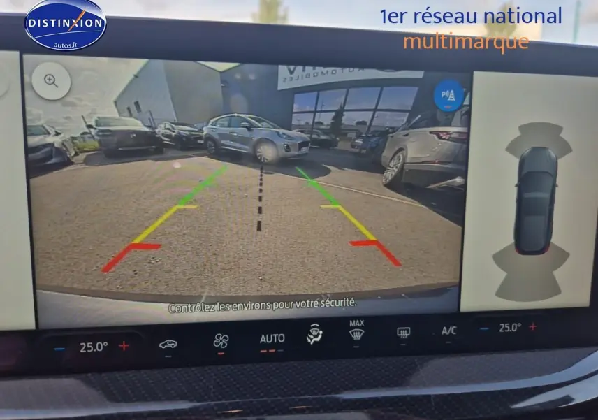 Écran de caméra de recul d'une Ford Focus gris magnétique, vue arrière avec lignes de guidage colorées.