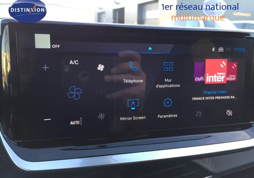 Écran tactile central de la Peugeot 208 hybride 2025 affichant les options téléphone et climatisation.