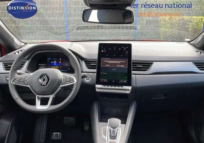 Vue intérieure du tableau de bord du Renault Captur E-Tech hybride 2025 avec écran tactile vertical et volant multifonction.