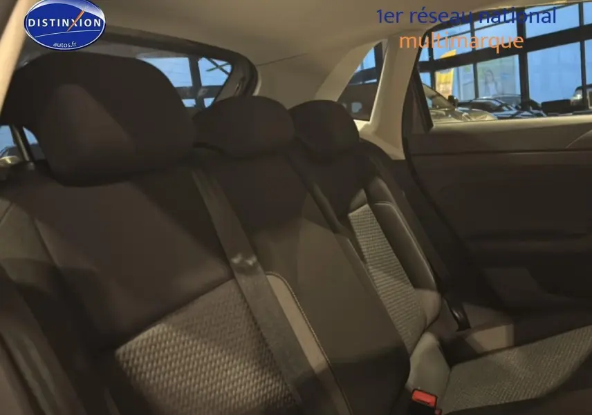 Vue intérieure côté droit montrant la banquette arrière en tissu noir avec motifs gris d'une Volkswagen Polo gris cendre.