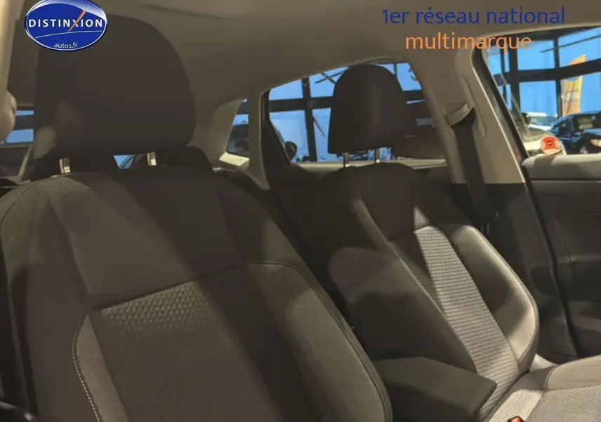 Vue intérieure côté avant droit montrant les sièges tissu noir de la Volkswagen Polo gris cendre 2025.