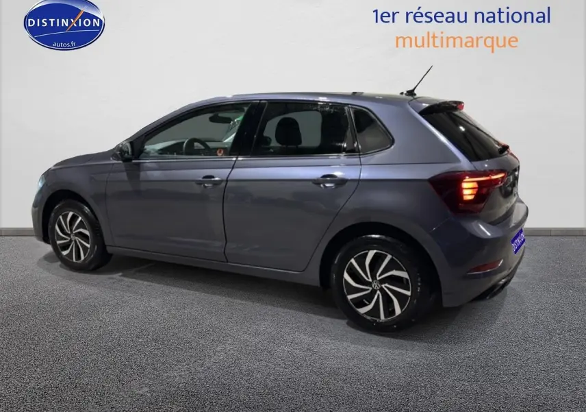 Volkswagen Polo gris cendre vue de profil côté gauche, feux arrière allumés et jantes alliage noires.
