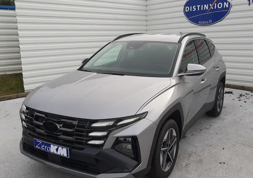 Vue 3/4 avant droite d'un Hyundai Tucson 2025 gris Shimmering Silver avec calandre noire et jantes bi-ton.