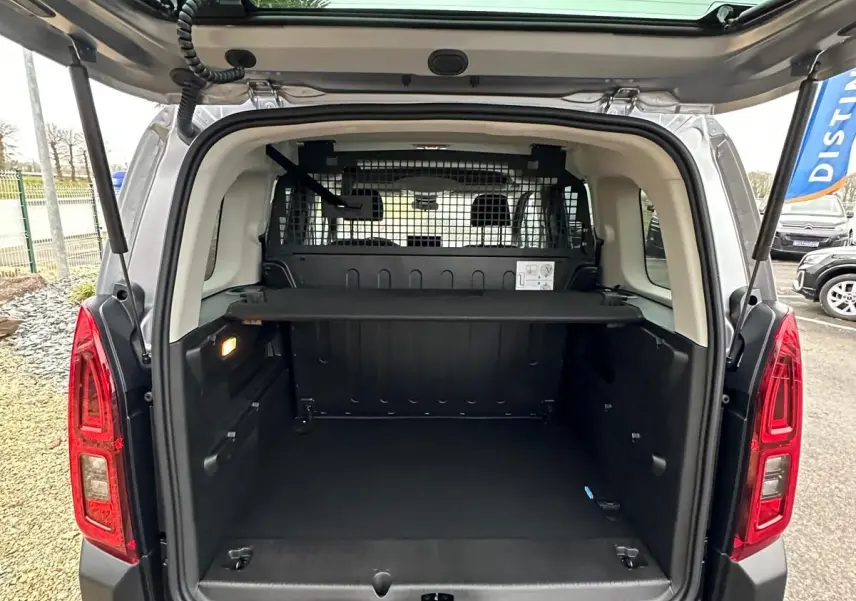 Vue arrière du Citroën Berlingo gris Artense 2025 avec coffre ouvert et séparation grillagée visible.