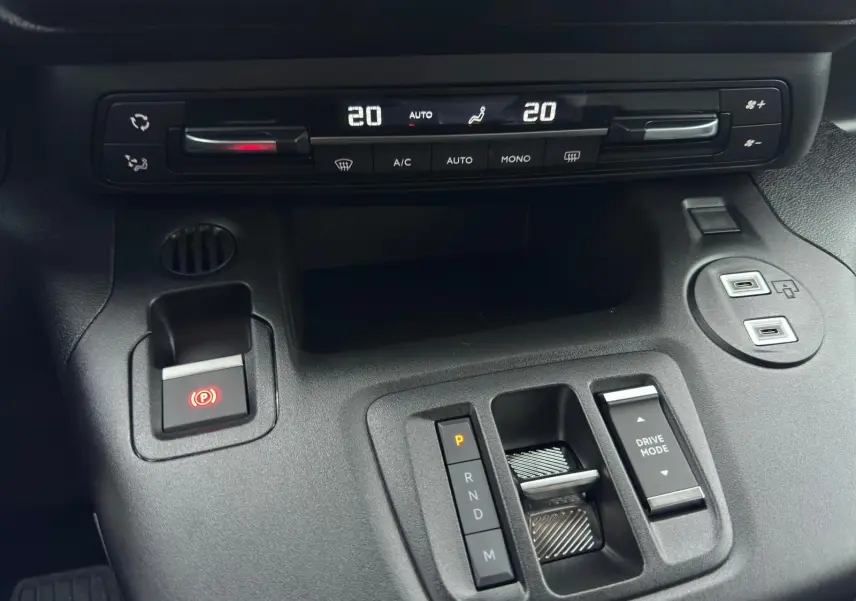 Vue rapprochée de la console centrale du Citroën Berlingo gris Artense 2025, avec commandes climatisation et boîte auto.