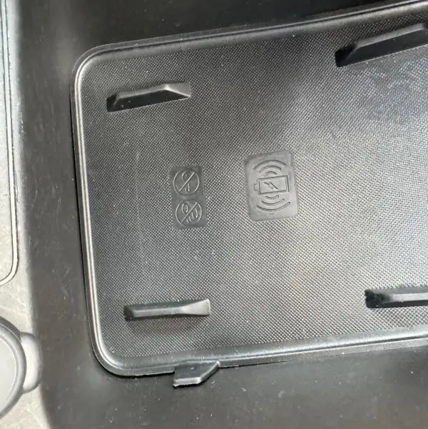 Détail du support de recharge sans fil noir dans l'habitacle du Jeep Avenger gris foncé 2025.