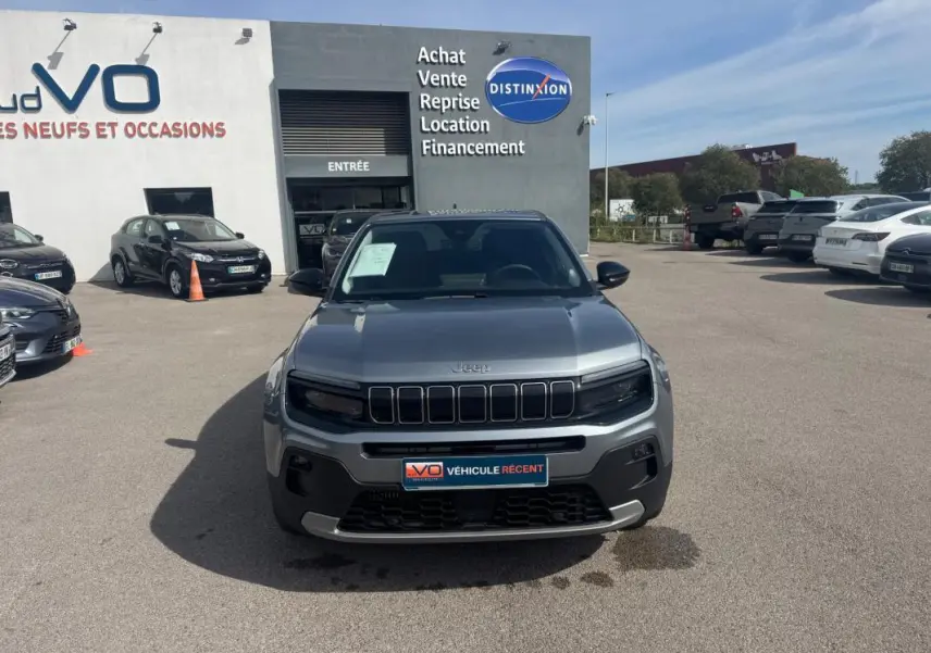 Vue de face d'un Jeep Avenger gris foncé 2025, version Summit, avec calandre distinctive et phares noirs.