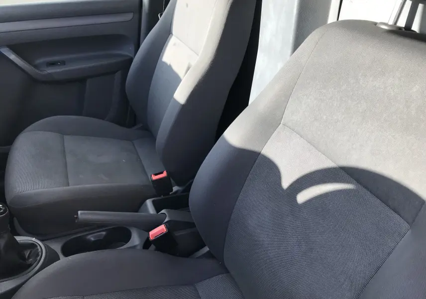 Intérieur du Volkswagen Caddy Maxi Van 2015, vue rapprochée des sièges avant en tissu noir et gris.