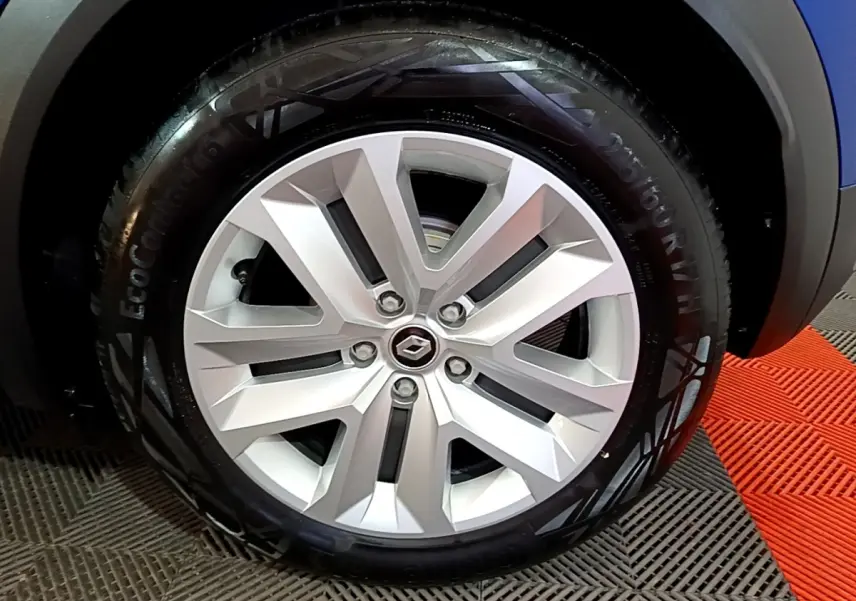 Gros plan sur la jante alliage argentée du Renault Captur bleu, mettant en valeur le logo central Renault.