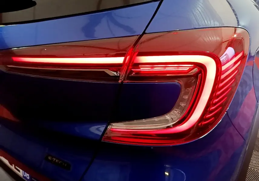 Gros plan sur le feu arrière droit rouge allumé du Renault Captur bleu E-Tech full hybrid 145 de 2023.