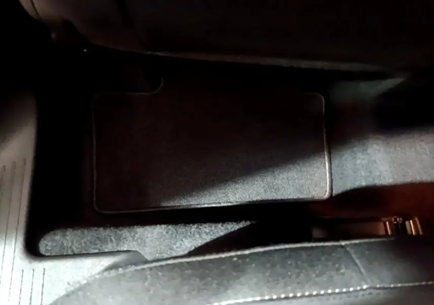 Vue rapprochée du tapis de sol arrière côté droit du Renault Captur bleu hybride 2023, avec moquette noire.