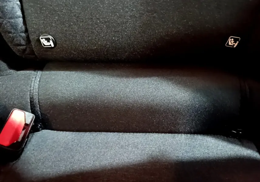 Gros plan sur la banquette arrière noire du Renault Captur 2023 avec indication Isofix et boucle de ceinture rouge visible.