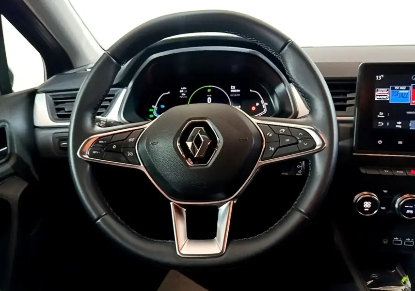 Vue intérieure centrée sur le volant cuir du Renault Captur 2023, avec tableau de bord numérique et écran tactile.