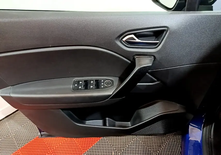 Vue intérieure du panneau de porte avant gauche du Renault Captur bleu, avec commandes électriques des vitres et poignée noire.