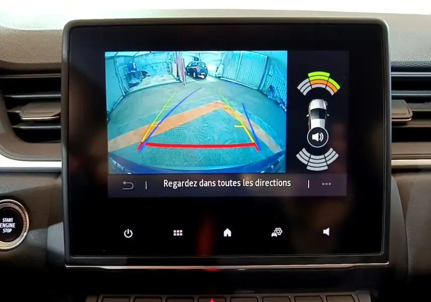 Écran tactile intérieur affichant la caméra de recul et l’aide au stationnement du Renault Captur bleu, vue du tableau de bord.