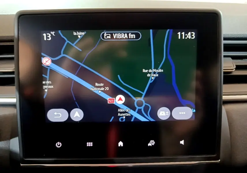 Écran tactile central du tableau de bord du Renault Captur bleu, affichant la navigation en vue 3D.