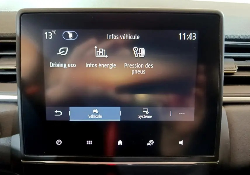 Écran tactile central du tableau de bord du Renault Captur 2023 affichant les infos véhicule en mode hybride.