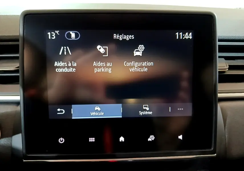 Écran tactile central du tableau de bord du Renault Captur bleu, affichant le menu réglages véhicule.