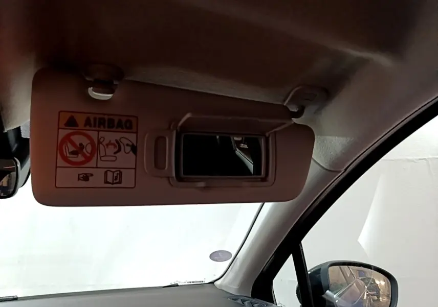 Détail intérieur sur le pare-soleil côté conducteur avec miroir et avertissement airbag dans un Renault Captur bleu 2023.