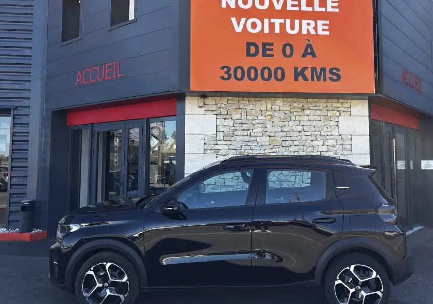 Vue de profil côté gauche d'une Citroën C3 noire 2025 avec jantes 16 pouces, stationnée devant un bâtiment commercial.