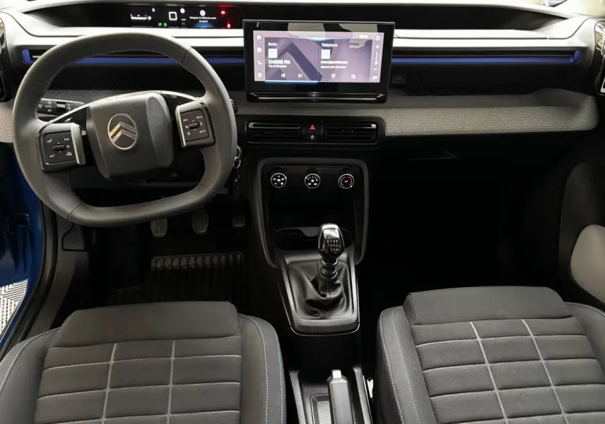 Vue intérieure avant de la Citroën C3 2025 noire, volant cuir multifonctions, écran tactile central 10,25 pouces et boîte manuelle.