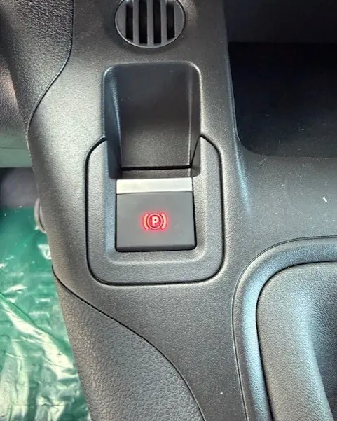 Gros plan sur le bouton de frein à main électrique rouge dans l'habitacle noir du Citroën Berlingo Van M Diesel 2026.