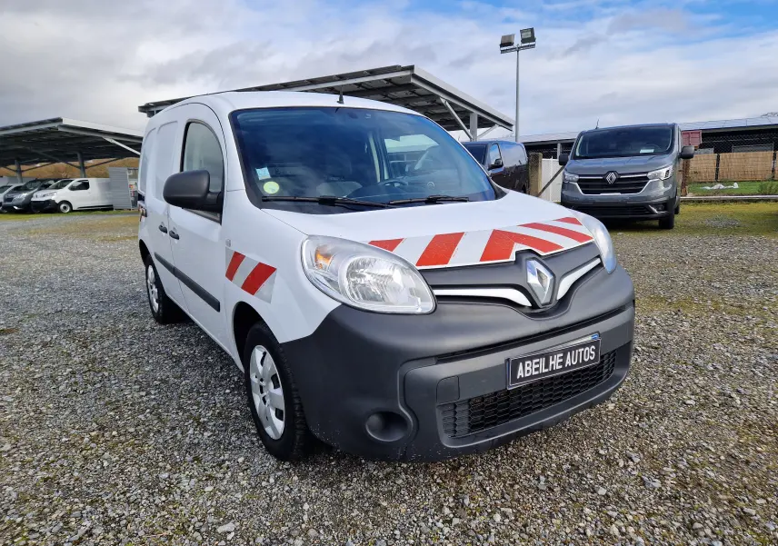 Vue 3/4 avant gauche d’un Renault Kangoo blanc 2020 avec bandes rouges diagonales sur capot et porte avant.