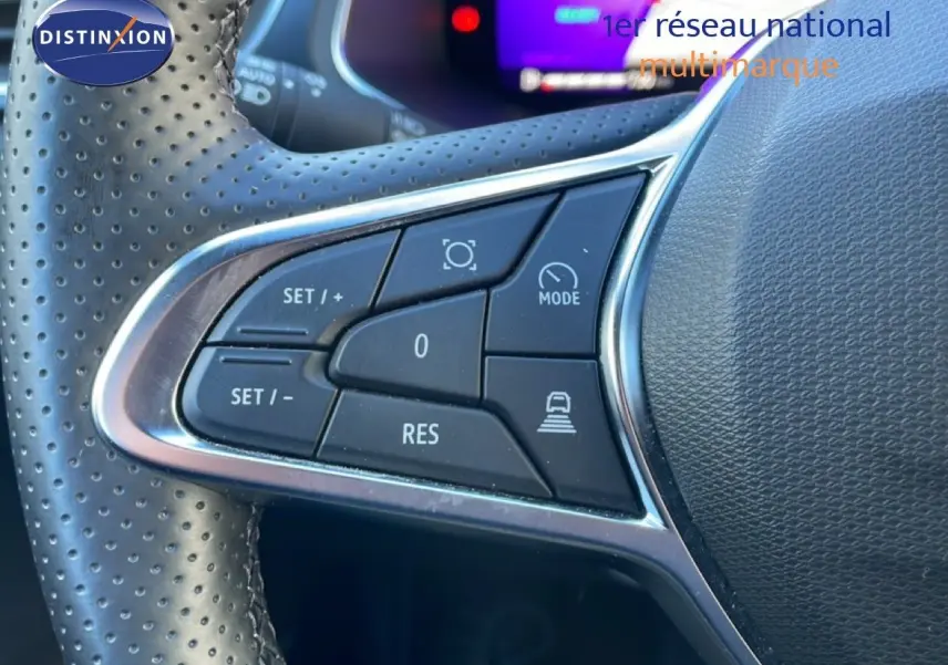 Gros plan sur les commandes de régulateur de vitesse au volant en cuir perforé du Renault Symbioz bleu Iron Metal.