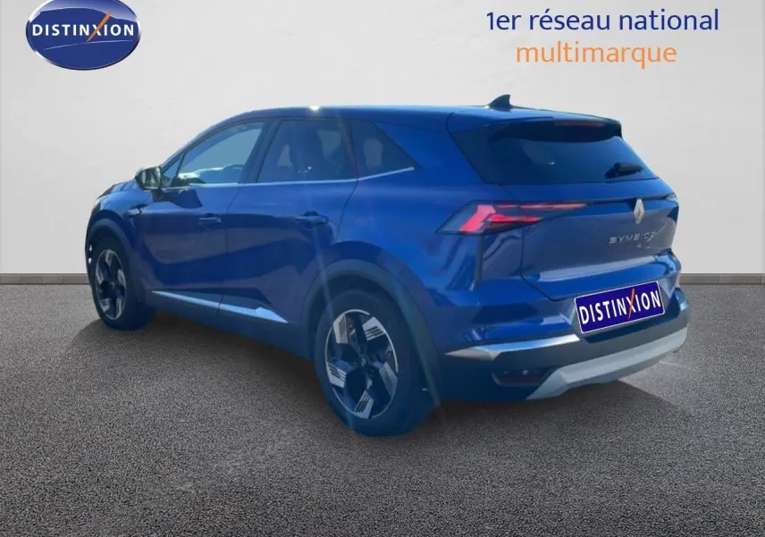 Renault Symbioz bleu iron metal en 3/4 arrière droit, mettant en valeur ses feux LED et ses jantes modernes.