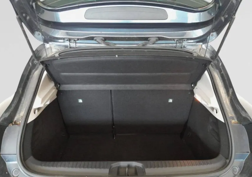 Coffre ouvert vu de l'arrière d'une Renault Clio V TCe 100 Business gris foncé de 2019, espace de chargement vide.