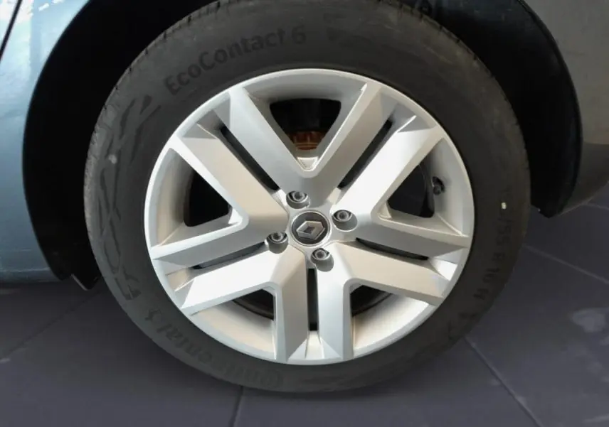 Gros plan sur la jante argentée de la Renault Clio gris foncé, mettant en valeur le logo central et le pneu Continental.