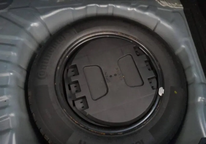 Gros plan sur la roue de secours noire dans le coffre d'une Renault Clio gris foncé, version V TCe 100 Business 2019.