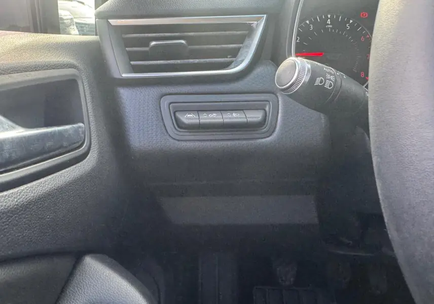 Détail intérieur côté gauche du tableau de bord de la Renault Clio gris foncé, avec commandes et levier d’éclairage visibles.