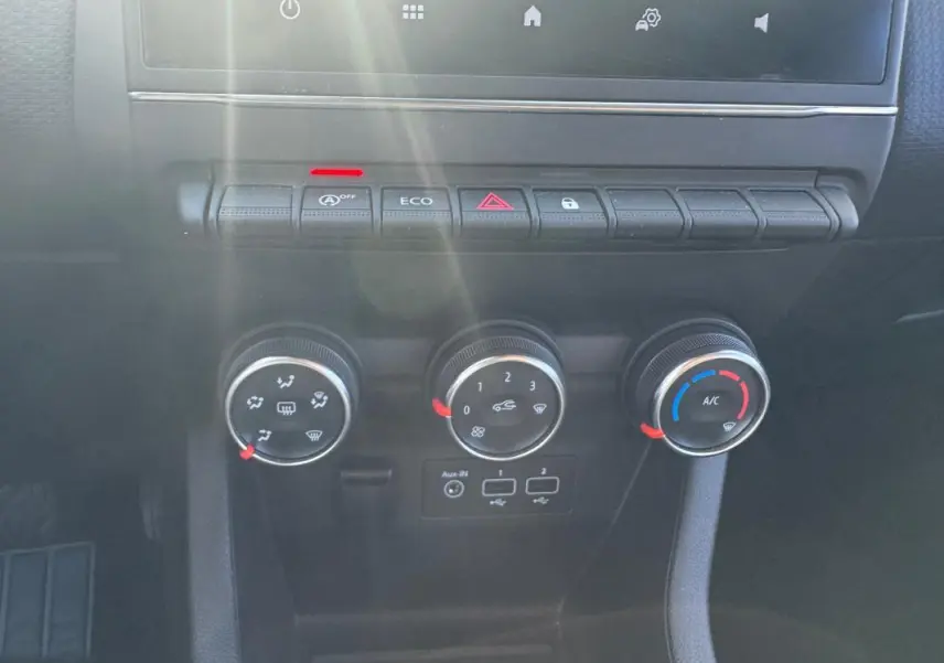 Vue rapprochée du tableau de bord de la Renault Clio 2019 gris foncé, montrant les commandes de climatisation et boutons fonctionnels.