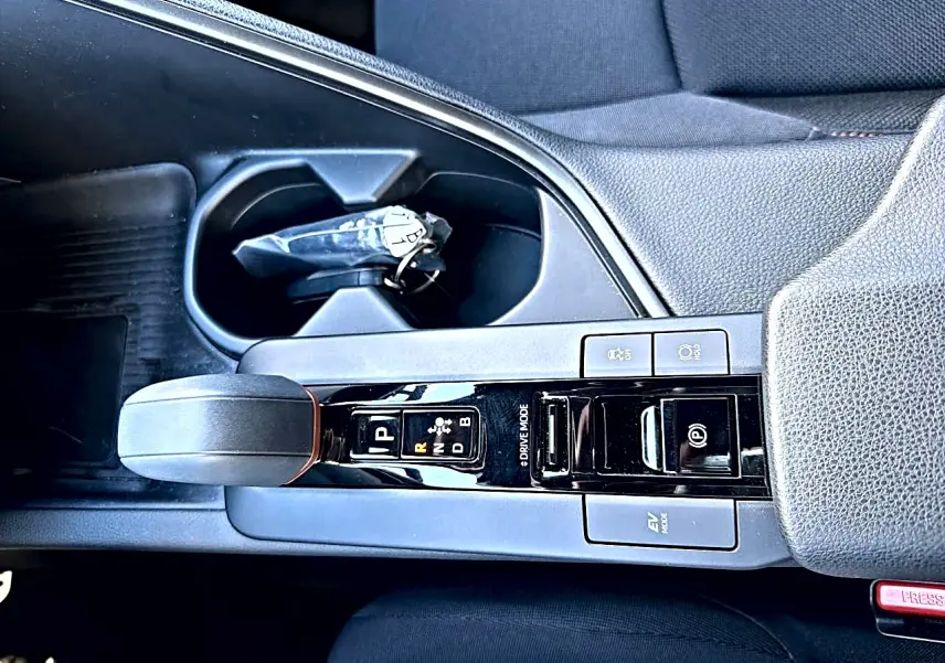 Vue rapprochée de la console centrale du Toyota C-HR gris, avec levier de vitesse automatique et accoudoir.