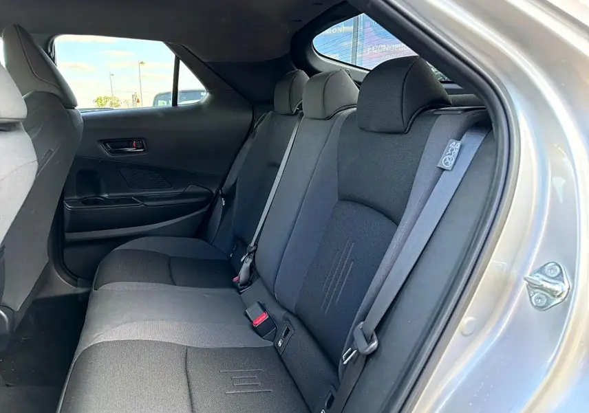 Vue intérieure côté droit sur la banquette arrière grise du Toyota C-HR 1.8 hybride 2025 avec ceinture de sécurité visible.